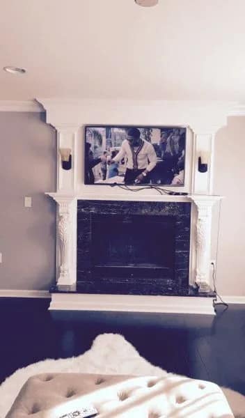 Detailed trim carpentry on a custom fireplace surround mantel with TV