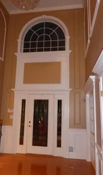Front entry doors framed with custom door casing and architectural trim