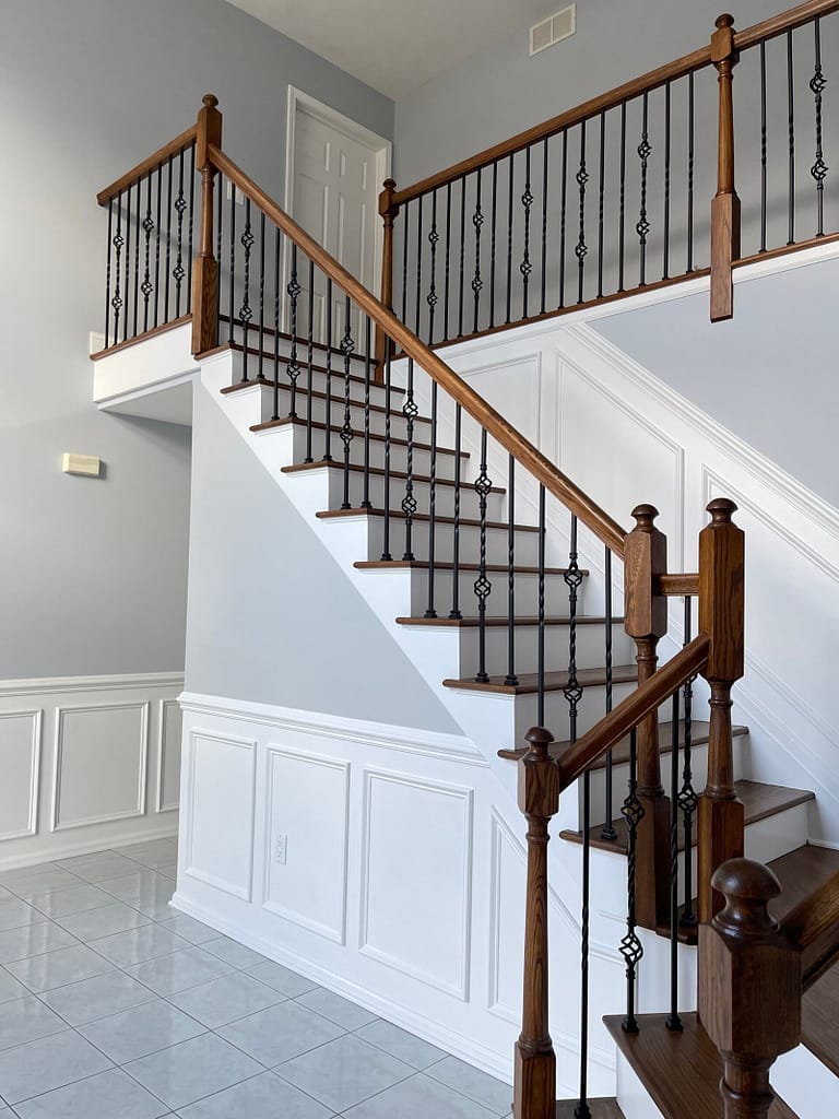Custom white wainscoting installed along a staircase and two-story foyer in Monmouth County, NJ