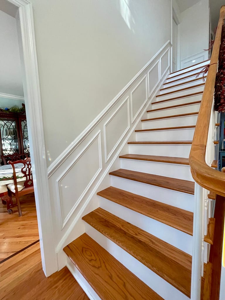 White staircase wainscoting with evenly spaced decorative wall panels
