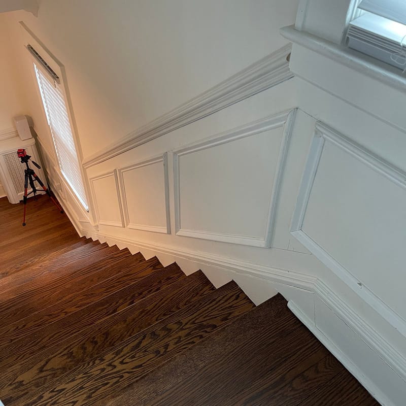 Custom picture-frame wainscoting fitted along an angled staircase wall
